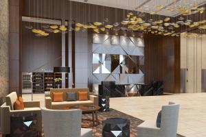 a lobby with couches and chairs and a chandelier at Courtyard by Marriott Surat in Surat +48 photos