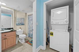 y baño con lavabo, lavadora y secadora. en Ocean Club Villa A-222, en Biloxi 8 fotos más