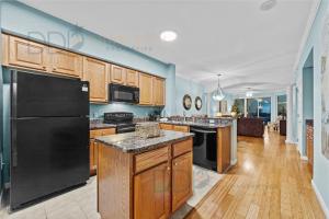 a kitchen with a black refrigerator and wooden cabinets at Legacy Tower I 903 in Gulfport