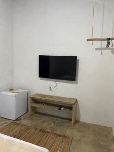a living room with a flat screen tv on a wall at Recanto da Alice in Trancoso +17 photos