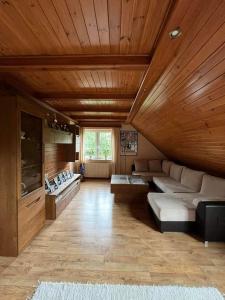 スピホボにあるLawendowy Domの木製の天井とソファ付きの広いリビングルーム