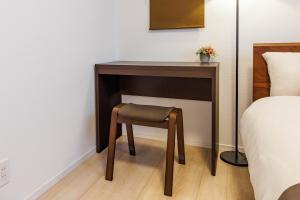 a small table with a stool next to a bed at New open! 15min drive to Naha airport#Villa in Itoman
