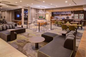 Un vestíbulo con mesas y sillas y un bar. en Courtyard by Marriott St Louis Chesterfield, en Chesterfield