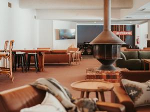 a living room with couches and a fire place at Matterhorn Lodge in Perisher Valley