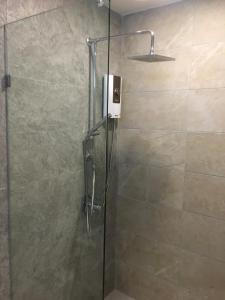a shower with a glass door and a shower head at 2 Bedder Beach Front Condo in Prime Location in Hua Hin