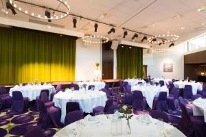 a banquet hall with white tables and purple chairs at Courtyard by Marriott Stockholm Kungsholmen in Stockholm