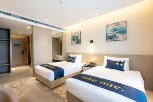 A bed or beds in a room at The Mulian Hotel, Chengdu Frontier Medical Center