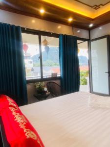 Un dormitorio con una cama y una ventana grande. en Hang Mua Bungalow, en Ninh Binh