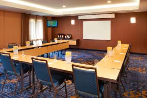 a conference room with tables and chairs and a projection screen at Courtyard Toledo Maumee/Arrowhead in Maumee