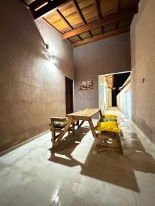 a wooden table in a room with a bench at Casa Carvalho in Peruíbe