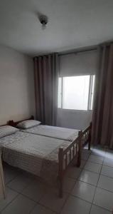 a bedroom with two twin beds and a window at Hostel Thiago in Santa Cruz