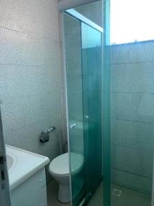 a bathroom with a toilet and a glass shower at Hostel Thiago in Santa Cruz