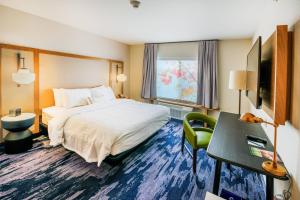 a hotel room with a bed and a desk and a television at Fairfield Inn & Suites Scranton Montage Mountain in Moosic +13 photos