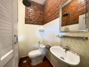 a small bathroom with a toilet and a sink at The Last Beach House in Kampot