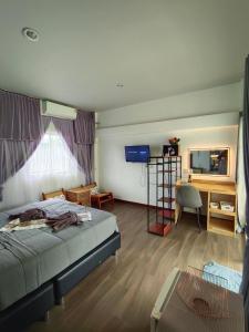 a bedroom with a bed and a desk and a television at บ้าน พัก ดี เกาะล้าน Ban Phak D Koh Larn in Ko Larn