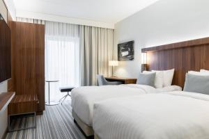 a hotel room with two beds and a desk at Courtyard Tampere City in Tampere