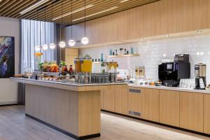 uma grande cozinha com um balcão num restaurante em Courtyard Tampere City em Tampere