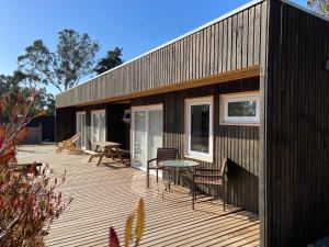 a wooden deck with a table and chairs on a house at Lodge Las Luces de Algarrobo in Algarrobo