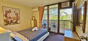 ein Schlafzimmer mit einem Bett und einem Balkon in der Unterkunft Casa Cinco Kalbarri - Kalbarri, WA in Kalbarri