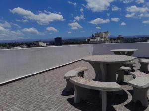 a group of tables and benches on a roof at Abuela Betty in Villa Carlos Paz