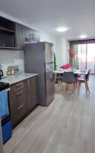 a kitchen with a stainless steel refrigerator and a dining room at Departamento zona 12 Guatemala in Boca Monte +16 photos