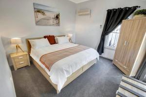 ein Schlafzimmer mit großem Bett und Fenster in der Unterkunft Beach and Lakes Cottage A in Lakes Entrance