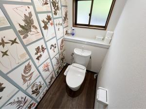 une petite salle de bain avec toilettes et fenêtre dans l'établissement アザミヴィラ青島, à Miyazaki