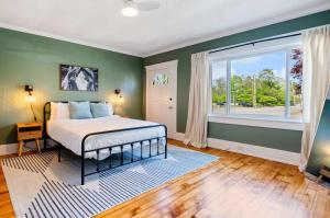 Un dormitorio con una cama y una ventana grande. en Stylish Retreat Walkable to Bars & Restaurants, en Louisville