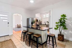 Una cocina con encimera y taburetes en una habitación. en Stylish Retreat Walkable to Bars & Restaurants, en Louisville