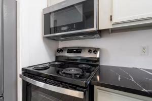 una cocina con estufa y microondas en Stylish Retreat Walkable to Bars & Restaurants, en Louisville