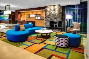 een woonkamer met blauwe meubels en een open haard bij Fairfield Inn & Suites by Marriott Douglas in Douglas