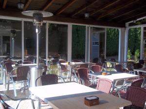 an empty patio with tables and chairs and windows at Hotel Suiza in Arzúa