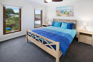 Un dormitorio con una cama con sábanas azules y una ventana. en Lake King Lakehouse, en Paynesville