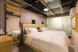 Llit o llits en una habitació de Dequan Hotel Chaoyang Park Branch Coffee fruits, snacks a gym and a laundry room are provided for free in the lobby