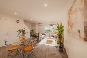 a living room with a glass table and chairs at Designer 2BR Flat - Outdoor Sitting & Cozy Ambiance in Christchurch