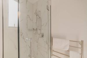 a bathroom with a shower with a glass door at Designer 2BR Flat - Outdoor Sitting & Cozy Ambiance in Christchurch +21 photos