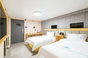 Llit o llits en una habitació de Dequan Hotel Chaoyang Park Branch Coffee fruits, snacks a gym and a laundry room are provided for free in the lobby