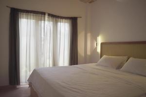 Un dormitorio con una cama blanca y una ventana. en Modern Villa With Pool 250m to Sea, en Ahangama