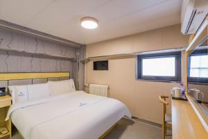 Llit o llits en una habitació de Dequan Hotel Chaoyang Park Branch Coffee fruits, snacks a gym and a laundry room are provided for free in the lobby