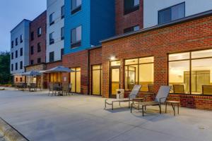a patio with chairs and tables in front of a brick building at Fairfield Inn & Suites by Marriott Asheville Weaverville in Weaverville