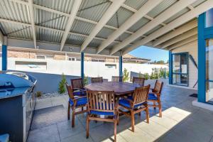 a patio with a table and chairs and a grill at Locanda in Paynesville