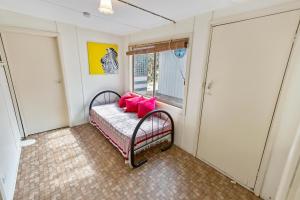 een kamer met een bank met roze kussens erop bij Kambera House in Raymond Island