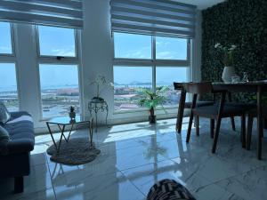 a living room with a table and chairs and windows at The Sands vista al mar espacioso elegante in Panama City