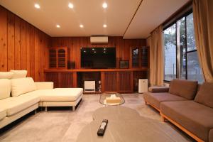 a living room with a couch and a tv at Nakai House in Tokyo