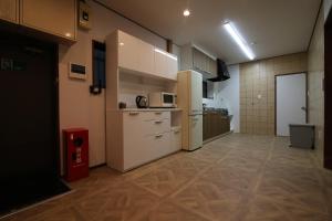a large kitchen with white appliances in a room at Nakai House in Tokyo