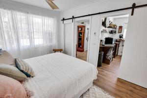 une chambre avec un lit blanc et une pièce avec un bureau dans l'établissement The Fishermans Cottage, à Raymond Island