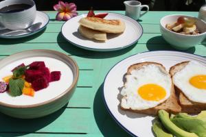 a table topped with plates of eggs and toast at Kalua Boutique Bungalows in Gili Trawangan