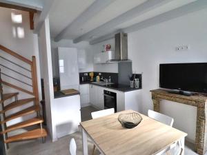 a kitchen with a table and a kitchen with a television at Charmante maison à Groix, 2 chambres - FR-1-813-14 in Groix