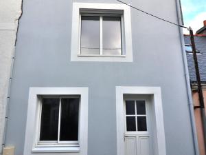a facade of a white building with two windows at Charmante maison à Groix, 2 chambres - FR-1-813-14 in Groix
