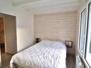 a bedroom with a white bed in a room with a window at Charmante maison à Groix, 2 chambres - FR-1-813-14 in Groix